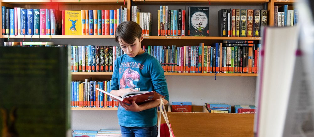 Ein Kind liest in einem Buch in der Katholischen Öffentlichen Bücherei an Sankt Cäcilia in Bonn am 10. September 2019.