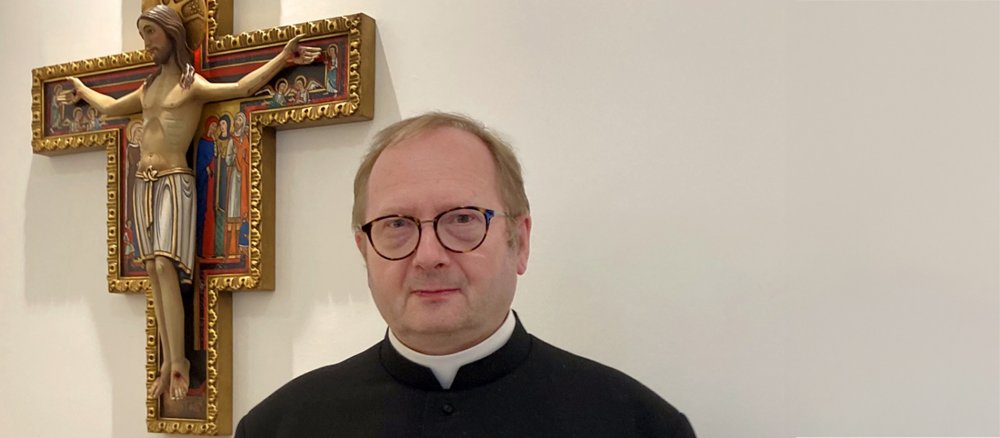 Portrait photo of David Waller next to a crucifix