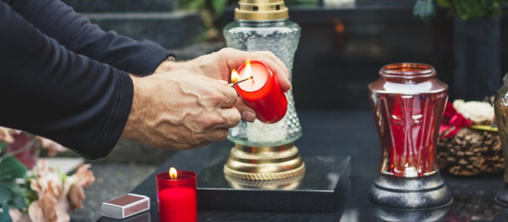 An Allerseelen wird eine Kerze auf dem Friedhof angezündet.