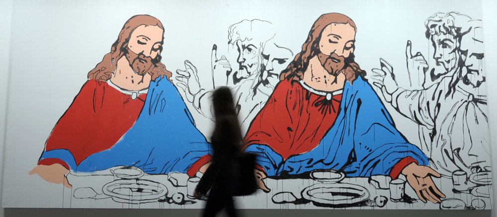 Eine Frau geht im Museum für Neue Kunst in Karlsruhe an dem Kunstwerk "Last Supper" von Andy Warhol vorbei.