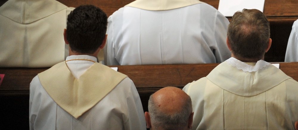 junger und alter Priester von hinten fotografiert