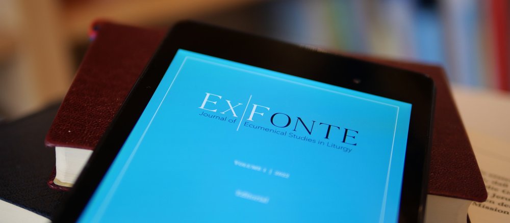 Ein Tablet mit der Titelseite der Zeitschrift "Ex fonte" liegt auf einem Bücherstapel"
