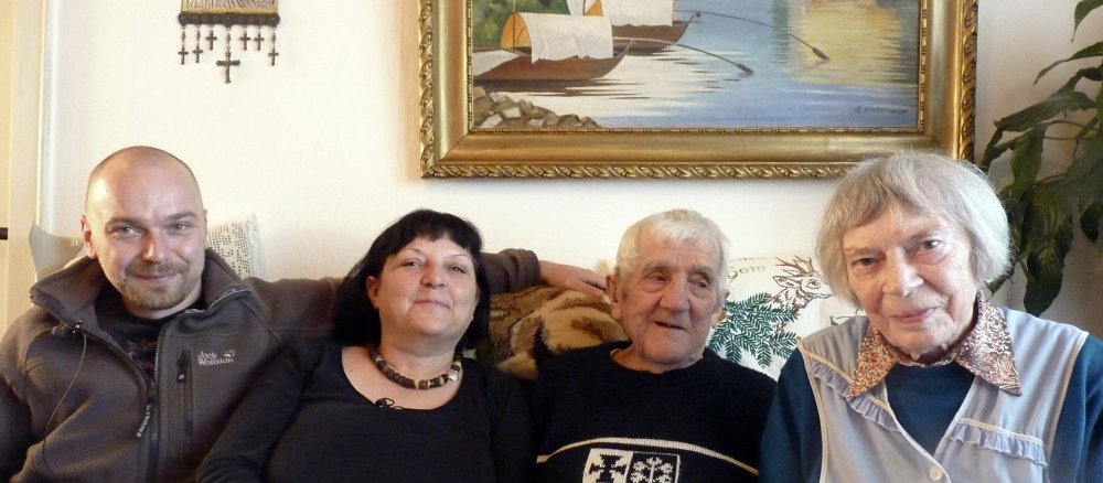 Vier Personen auf einer Sitzgruppe mir Bild