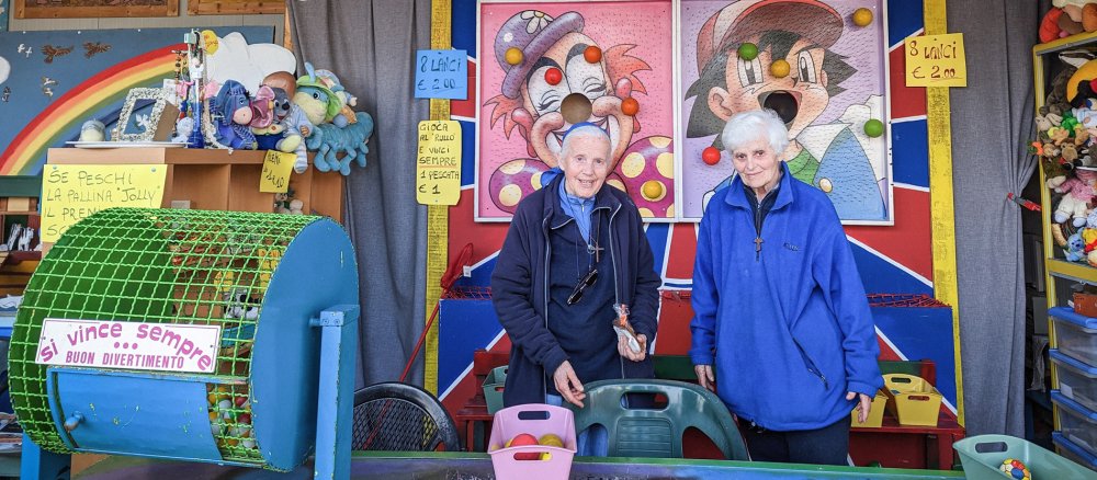 Zwei Ordensfrauen stehen in einer Kirmesbude