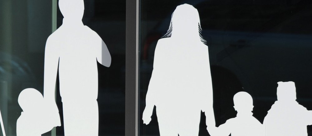 Papierfiguren von einem Vater mit Kind und einer Frau mit Kindern.