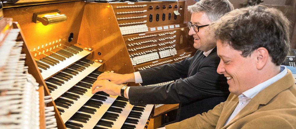 Bischof Peter Kohlgraf sitzt mit dem Mainzer Domorganist Daniel Beckmann an der Orgel.