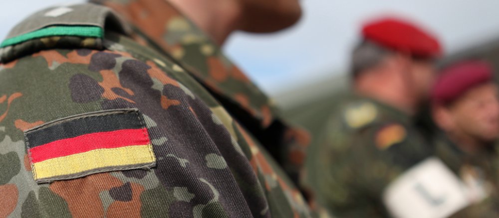 Die Deutschland-Flagge ist auf der Tarnkleidung eines Soldaten zu sehen.