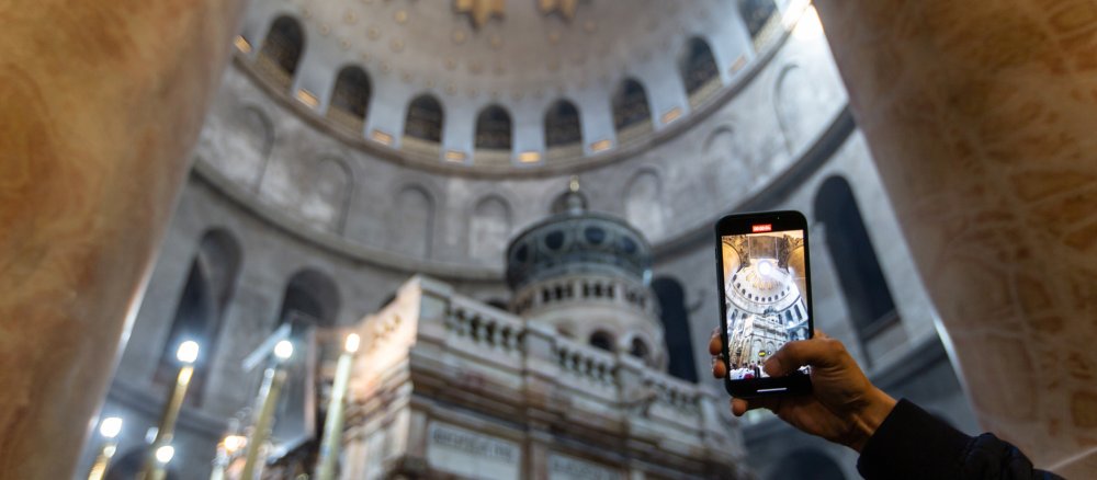 A visitor takes a video with his smartphone of the dome of the Church of the Holy Sepulchre in Jerusalem