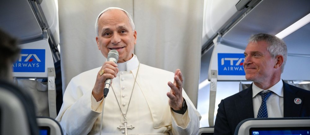 Papst Leo XIV. bei einer seiner fliegenden Pressekonferenzen mit einem Mikrofon in der Hand