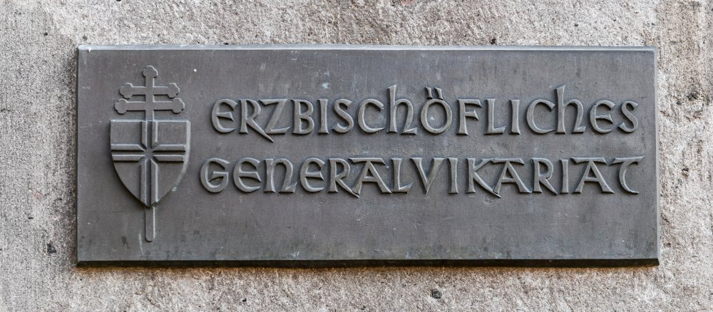Schild des Erzbischöflichen Generalvikariats in Köln mit dem Wappen des Erzbistums