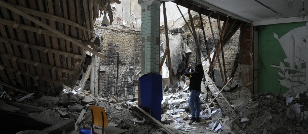 Eine Frau macht ein Foto in einem zerstörten Gebäude in der Nähe von Kiew