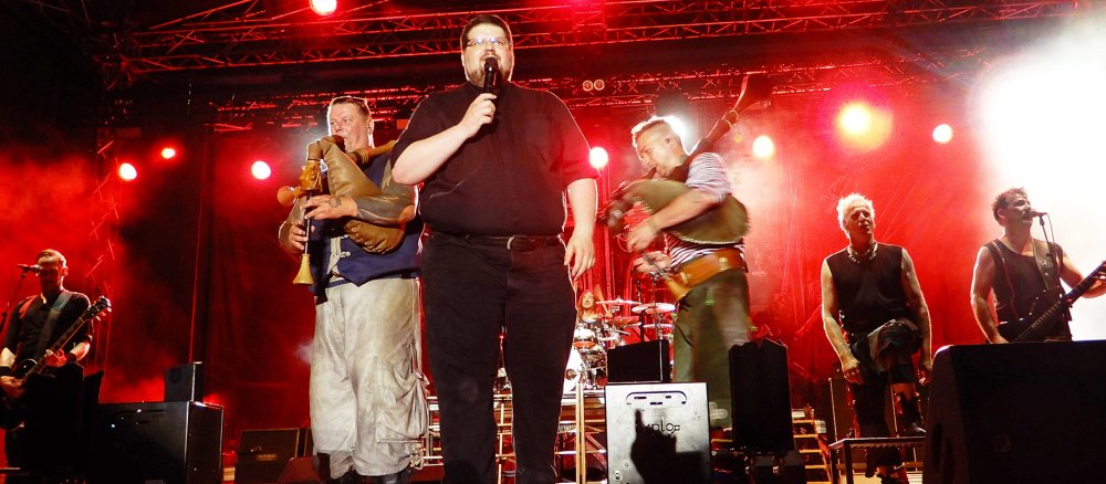 Kaplan Guido Funke steht bei einem Auftritt der Band "In Extremo" auf der Bühne