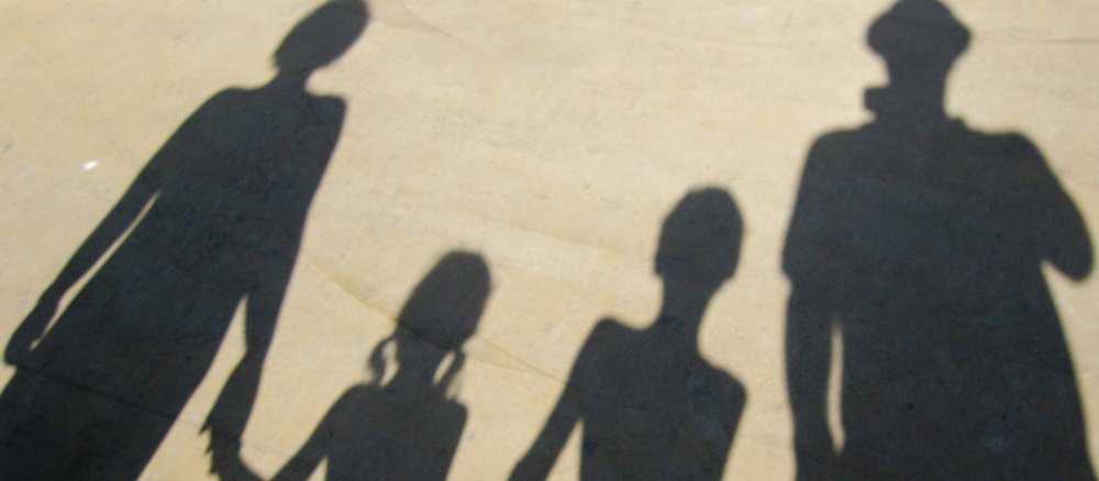 Eine Familie fotografiert ihren Schatten.