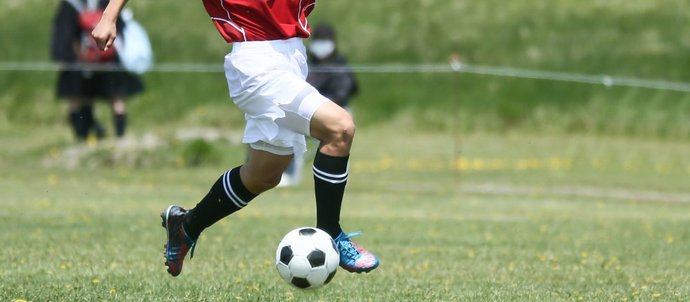 Ein Fußballspieler tritt gegen den Ball.