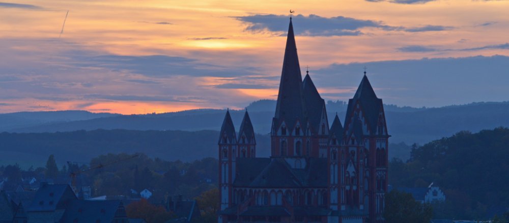 Die Sonne geht am 21.10.2013 in Limburg (Hessen) hinter dem Dom der Stadt unter.