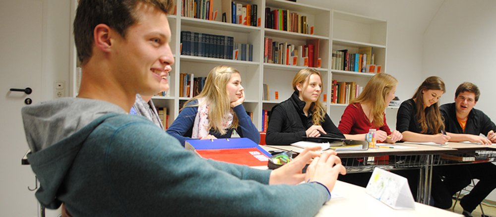 Junge Leute sitzen gemeinsam in einem Klassenraum