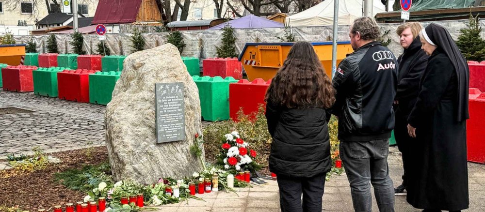 Am ersten Jahrestag stehen Menschen vor dem Gedenkstein, in Gedenken an die Opfer und Betroffenen des Weihnachtsmarkt-Anschlags, am 20. Dezember 2025 in Magdeburg.