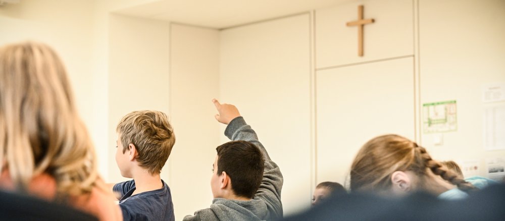 Ein Schüler meldet sich im Religionsunterricht