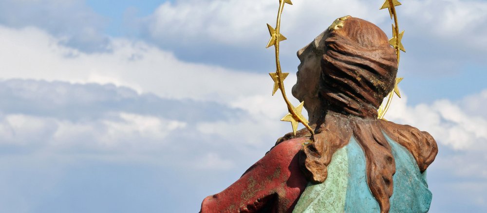 Eine Madonnenstatue vor blauem Hintergrund
