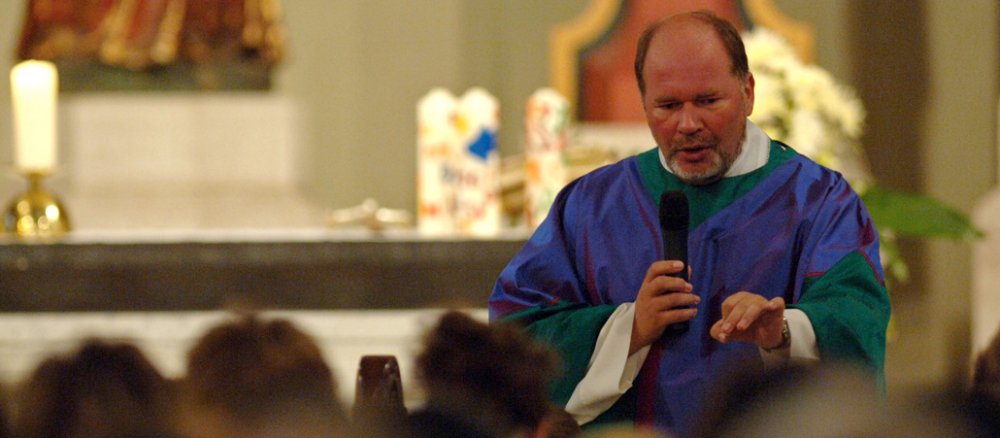Ein Pfarrer spricht im Gottesdienst mit seiner Gemeinde.