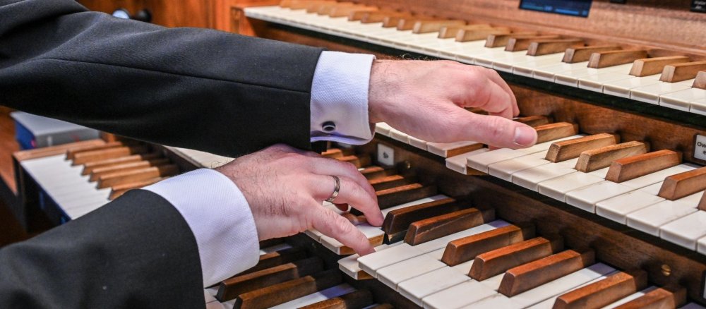 Ein Kirchenmusiker spielt auf einer Orgel