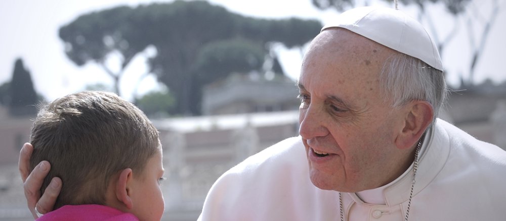 Der Papst hält den Kopf des Kindes.