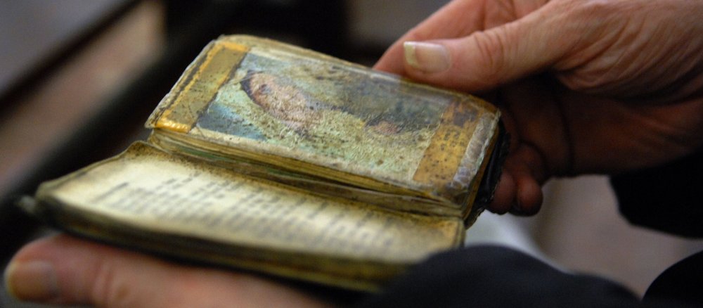 Ein Mann betet mit einer Bibel in der Hand in der Basilika des Heiligtums von Fatima.