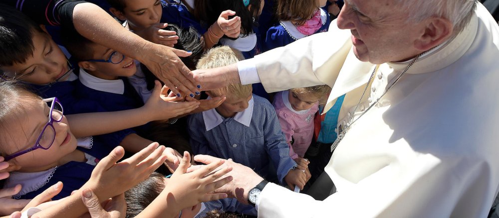 Pope Francis shakes hands with children