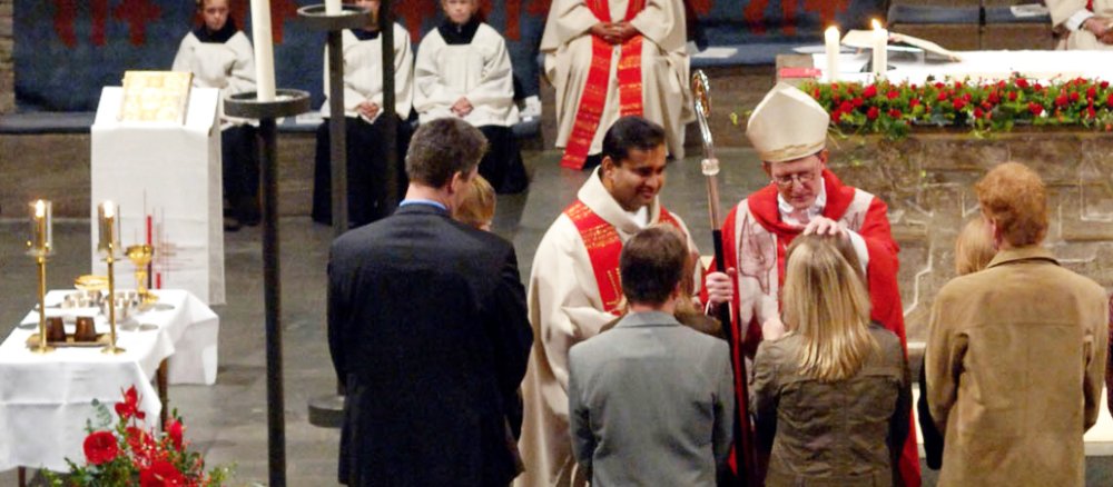 Jugendliche stehen in einer Reihe vor dem Altar und empfangen von Bischof Woelki die Firmung.