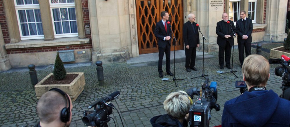 Marx, Zollitsch und Kopp vor Mikrofonen