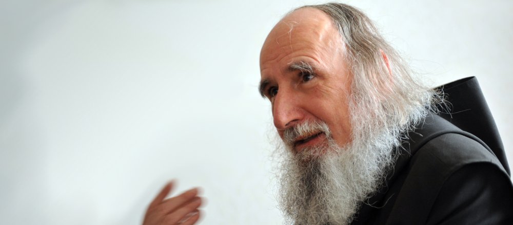 Anselm Grün, ein älterer Benediktinermönch mit langem grauen Bart und schulterlangen Haaren.
