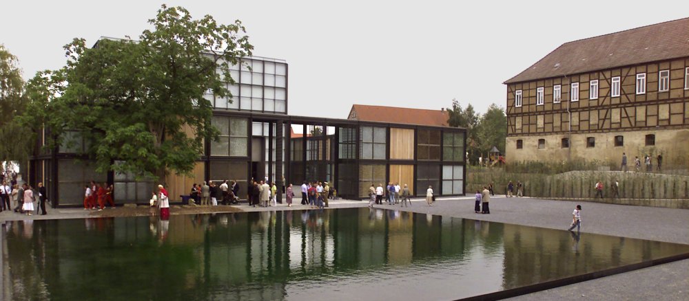 Eine Klosteranlage mit einem modernen, würfelförmigen Kirchenbau.