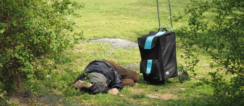 Ein obdachloser Flüchtling schläft im Park.