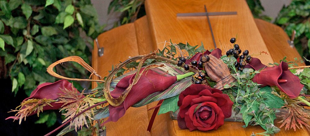 Ein Sarg mit Sargschmuck steht in der Begräbniskapelle.