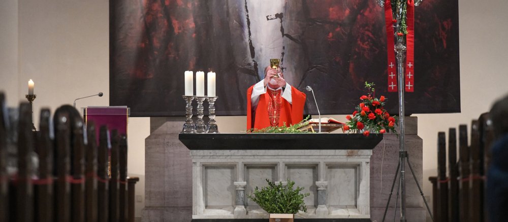 Der Priester am Altar erhebt den Kelch während des Gottesdienstes