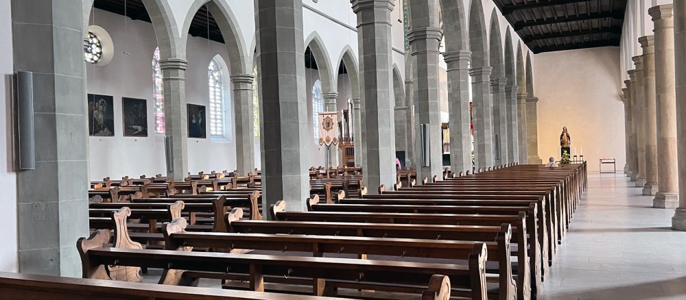 In der Ravensburger Liebfrauenkirche sitzt eine Frau und betet.