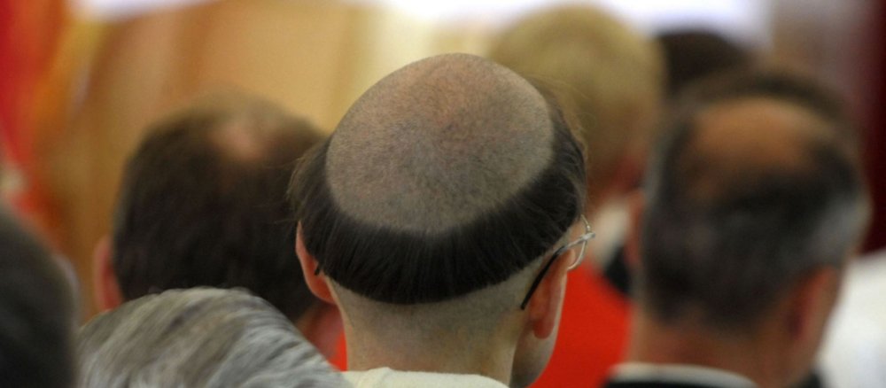 Das Bild zeigt einen Ordensbruder mit Tonsur von hinten.