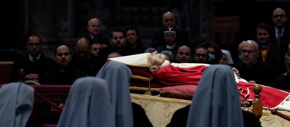 Ordensschwestern und weitere Menschen blicken auf den aufgebahrten Leichnam des emeritierten Papstes Benedikt XVI.