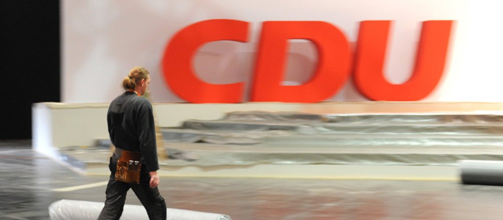 Ein Mann verlegt Teppichboden beim Aufbau für den 25. Bundesparteitag der CDU Deutschlands in Hannover (Niedersachsen).