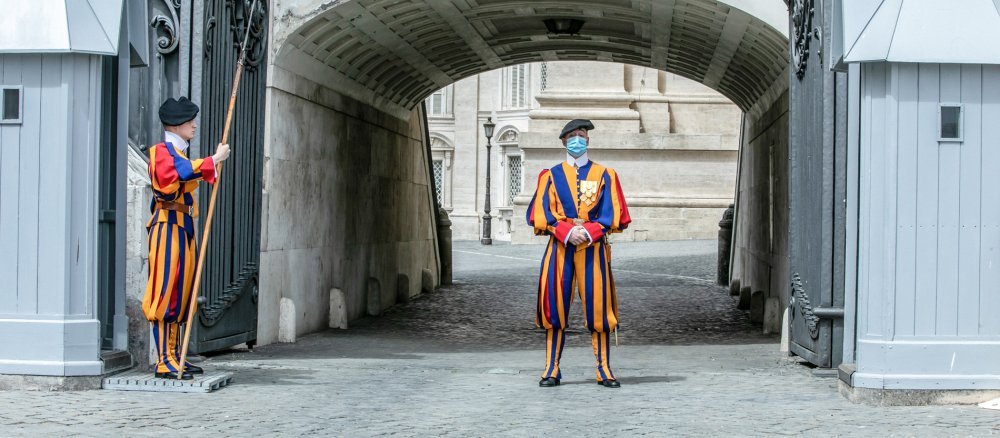 Ein Gardist der Schweizergarde trägt traditionelle Uniform und Mundschutz