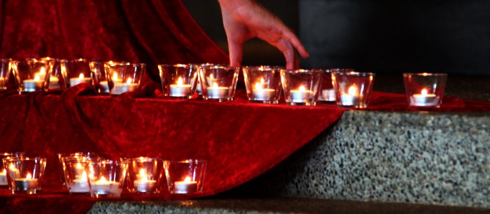 Dutzende Kerzen stehen angezündet auf den Stufen zum Altar.