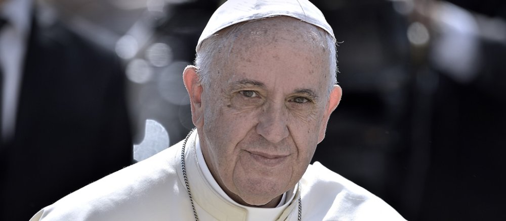 Papst Franziskus schaut lächelnd in die Kamera.