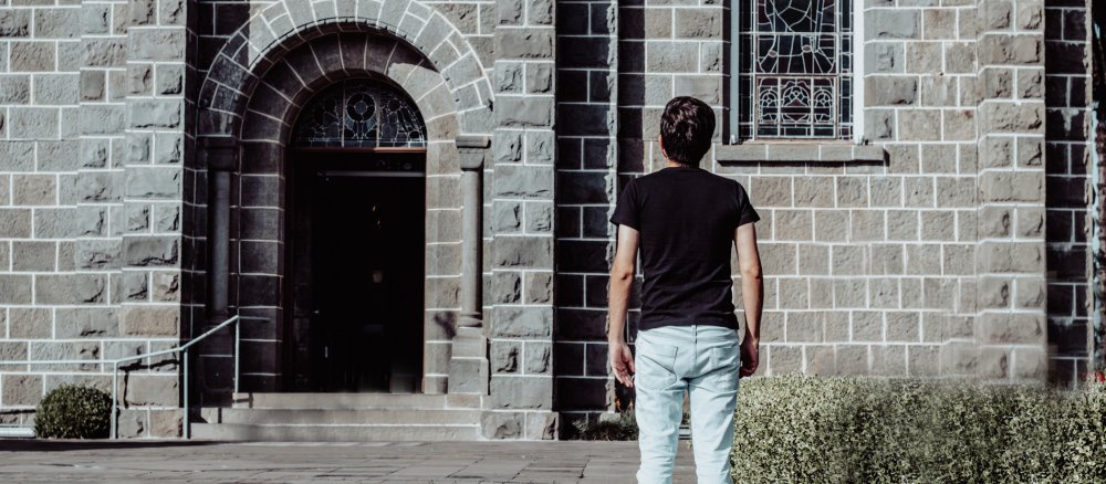 Mann steht vor Kirche