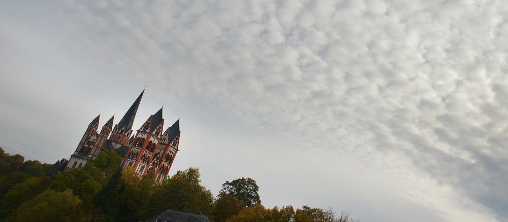 Ein Himmel mit Wolken, links im Bild der Limburger Dom