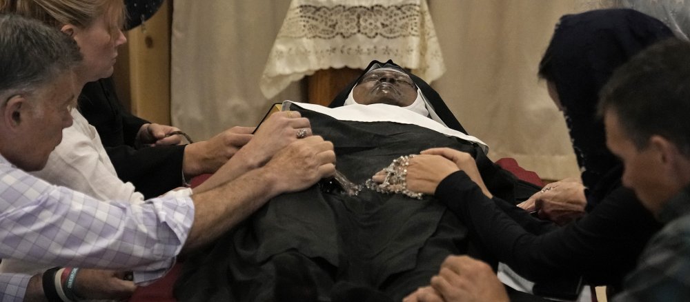 Believers pray at the body of the deceased nun Wilhelmina Lancaster
