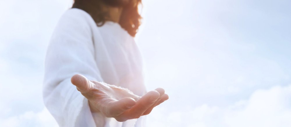 Eine Person, die wie Jesus aussehen soll, streckt die Hand aus.