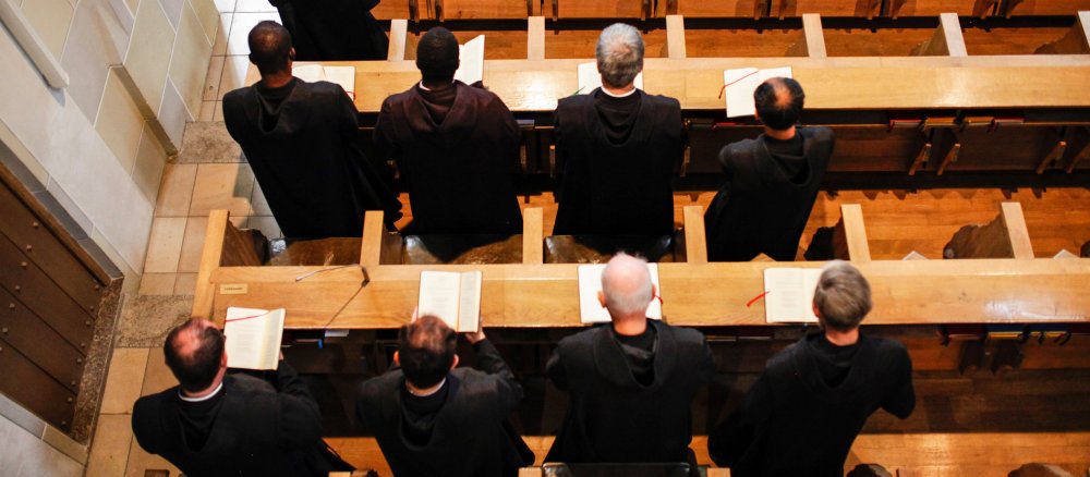 Mehrere Benediktiner singen bei einem Gottesdienst in der Klosterkirche