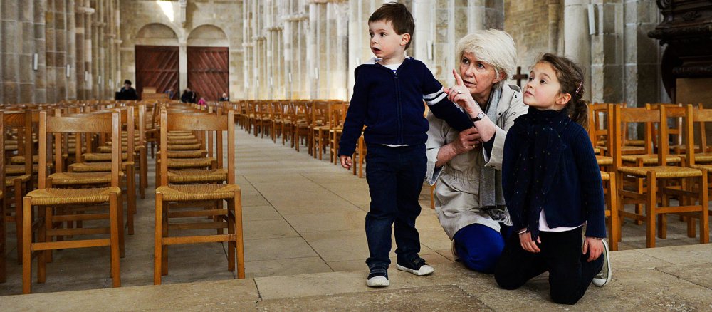 Eine Großmutter zeigt ihren kleinen Enkeln eine Kirche.
