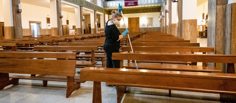 Eine Frau reinigt eine Kirche