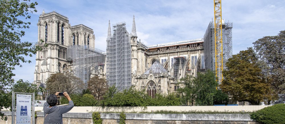 A woman photographs the partially scaffolded Notre-Dame Cathedral on 19 September 2021 in Paris.
